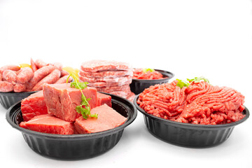 Side View of Assorted Raw Beef Products Minced Meat, Steaks, Sausages, and Burger Patties Isolated on White Background