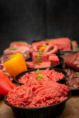 Assorted Raw Beef Meats on Table with Black Background Side View