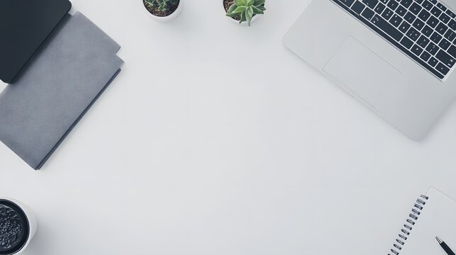 A birds-eye view of a simple desk setup with a notebook, a pen, and a laptop, creating a clean and organized workspace with minimal distractions.