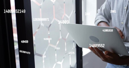 Image of data processing over african american businessman using laptop in office