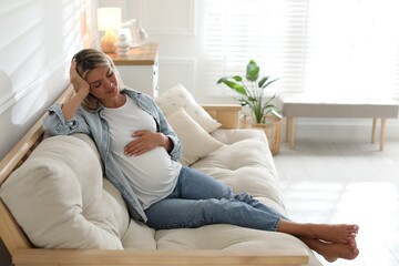 Portrait of beautiful pregnant woman on sofa at home