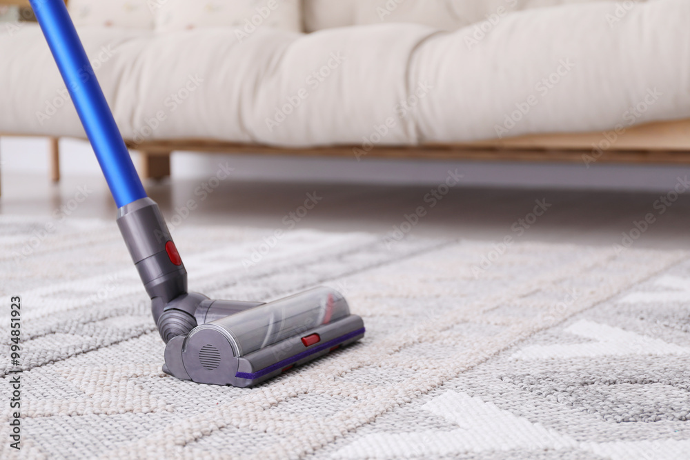 Poster Cleaning with wireless handheld vacuum cleaner indoors, closeup