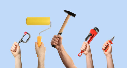 Hands of people with different tools on light blue background
