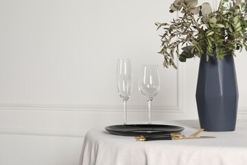 Stylish table setting with black dishware in dining room, space for text