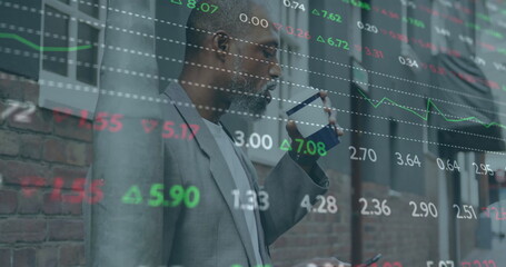 Image of financial data processing over african american man drinking coffee in city