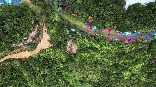 Colorful Camp in Papandayan's Green Forest. Vibrant tents and hammocks nestled amidst lush greenery. Perfect for travel, adventure, and nature documentaries.