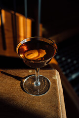 Manhattan whiskey cocktail with orange peel garnish in coupe glass