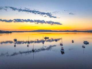 Autumn sunrise over the bay with boats and reflections
