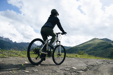 Naklejka premium Woman riding mountain bike in the beautiful mountains