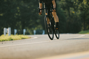 Woman cycling on summer park trail