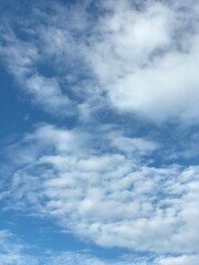clear blue sky with scattered cloud in the middle of the day