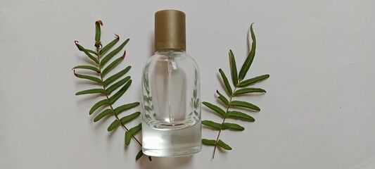 perfume bottle and Pellaea atropurpurea leaves, on a white background