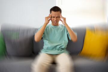 Young Asian Male Feels Dizzy While Sitting on Sofa With Feeling Pain and Spinning Sensation in His...