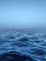 Fototapeta premium Tranquil Ocean Horizon, a serene landscape featuring a vast expanse of blue water with soft rolling waves. The image evokes feelings of peace, tranquility, and vastness.