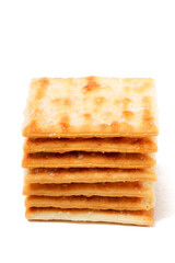 A stack of sweet crispy cracker sprinkled with sugar on top, set against a clean white background. The golden brown crackers create a simple yet appetizing display