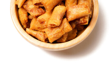 A bowl of Sumpia, Indonesian traditional mini spring rolls filled with shrimp floss. The crunchy outer wrapper is deep-fried to perfection. Photographed on a white background.
