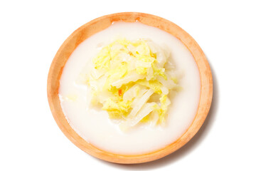 Chopped cooked napa cabbage served in savory coconut milk broth, perfect as a side dish with rice. Photographed on a white background.