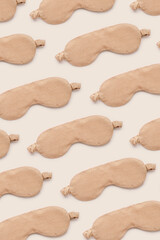 Minimal style monochrome pattern made from beige sleeping masks. Female eye masks for best sleepers, for travel, comfort relaxation. Sleep well concept. Creative aesthetic top view photo