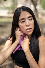 finishing a workout routine a young woman with straight hair, using a towel to dry her sweat, healthy lifestyle and wellness