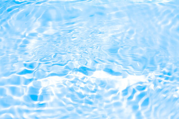 Blue water with ripples on the surface. Defocus blurred transparent blue colored clear calm water surface texture with splashes and bubbles. Water waves with shining pattern texture background.