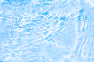 Obraz premium Blue water with ripples on the surface. Defocus blurred transparent blue colored clear calm water surface texture with splashes and bubbles. Water waves with shining pattern texture background.