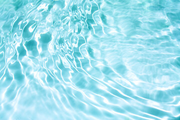 Blue water with ripples on the surface. Defocus blurred transparent blue colored clear calm water surface texture with splashes and bubbles. Water waves with shining pattern texture background.