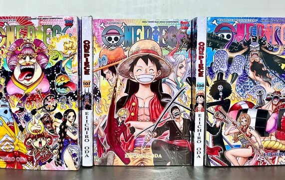 Jakarta, Indonesia - September 12th, 2024 - One piece famous manga comic book series number 99 and 100 isolated on horizontal ratio store bookshelf background.