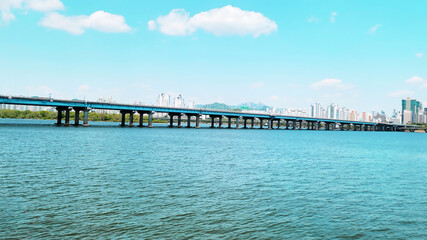 Obraz premium panorama view of the river, Yeouido Hangang River Park, in Seoul, Korea, with a broad bridge, and a cityscape in the backdrop 