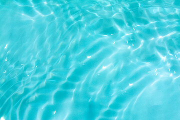 Blue water with ripples on the surface. Defocus blurred transparent blue colored clear calm water surface texture with splashes and bubbles. Water waves with shining pattern texture background.