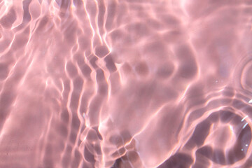 Pink water bubbles on the surface ripples. Defocus blurred transparent pink colored clear calm...
