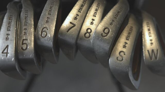 slow panning shot of a full set of golf irons and wedges in a golfers bag