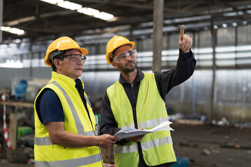 Group of male engineer worker discuss and working together in industry factory. Male engineer repairing or maintenance CNC machine in factory