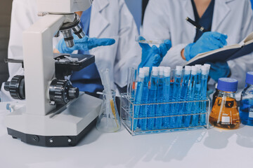 Scientist using microscope in laboratory. Close-up of a researcher's hands adjusting a modern...