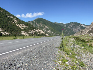 Naklejka premium Mountain landscape with asphalt road and blue sky, Mountain Altai.