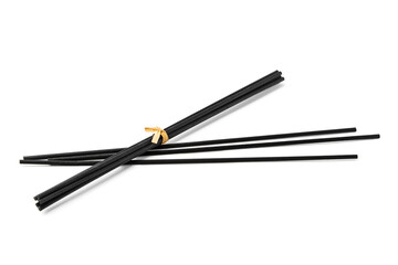 Black aromatic sticks resting on a plain white background