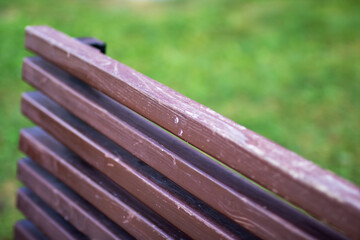Fototapeta premium This is a close up image of a wooden bench with green grass in the background