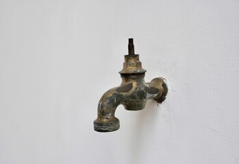 Old and aged rusty iron water faucet with missing valve handle part isolated on horizontal ratio...
