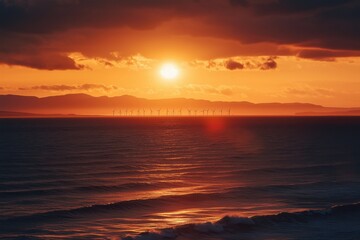 Obraz premium Sunset view over the sea towards a distant offshore wind farm