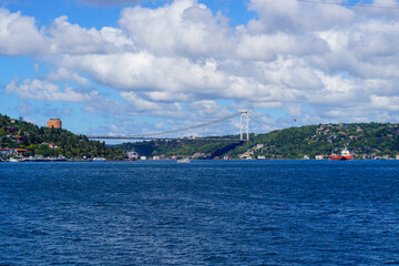 Fototapeta premium Bosphorus Bridge spans the skyline of Istanbul while overseeing the Rumeli Fortress and the vibrant coastline below