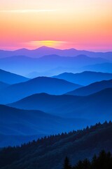 Fototapeta premium A breathtaking sunset paints the mountains in hues of blue and purple as soft clouds linger over the distant peaks