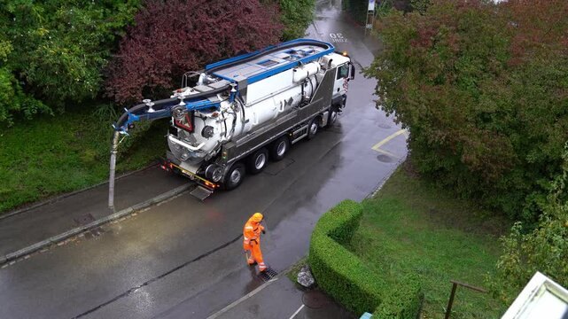 High angle view of sewer truck leaving after cleaning on a rainy autumn morning at Swiss City of Z&uuml;rich. Movie shot September 26th, 2024, Zurich, Switzerland.