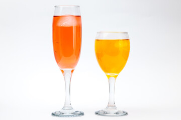 Two glasses with different liquors on white background.