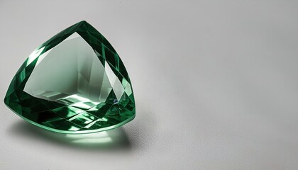 Emerald is a gemstone and a variety of the mineral beryl colored green by trace amounts of chromium or sometimes vanadium. Isolated on white background with copy space. Cut and shaped
