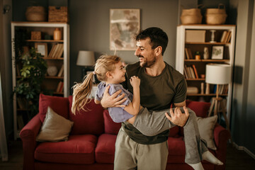 Father and his little daughter dancing and having fun during their time at home together