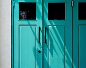 Blue double door with pull handles isolated on horizontal ratio building exterior background.