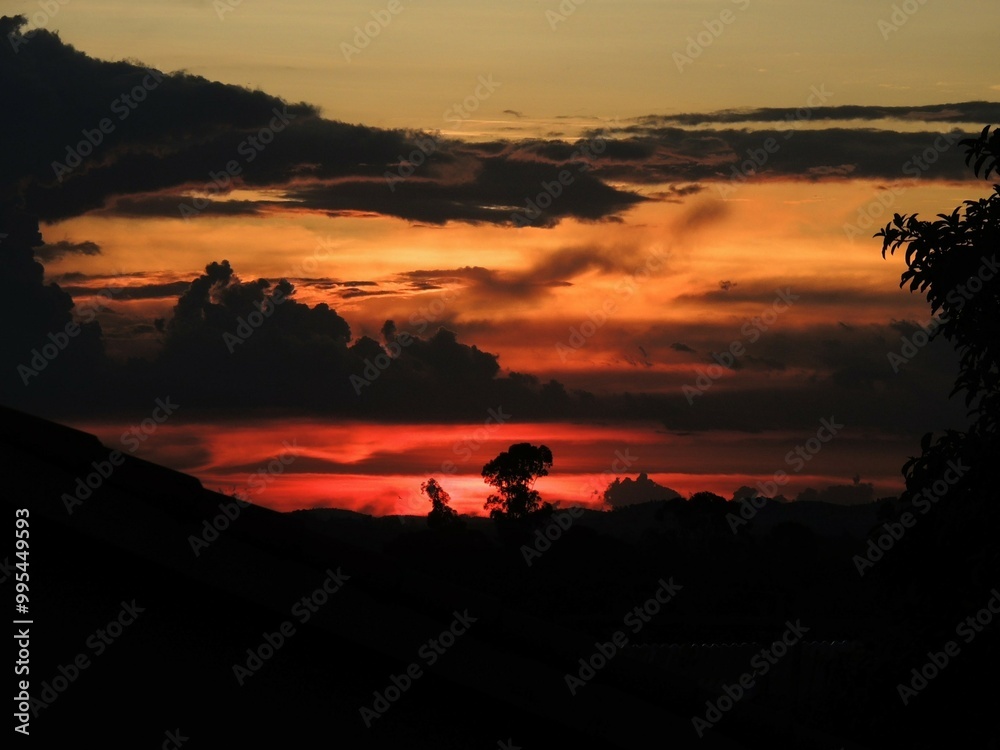 Wall mural a stunning sunset captured with a dramatic sky filled with vibrant hues of orange and red.