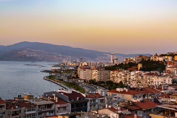 Panoramic view of Izmir coastline at sunset with modern cityscape and Aegean Sea panorama. Izmir, Turkey (Turkiye)