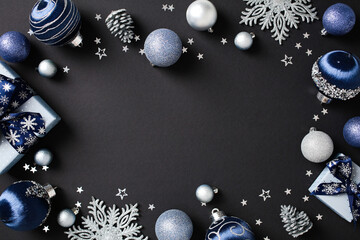 Frame of elegant Christmas decor and gift boxes in blue and silver hues on a dark backdrop, perfect for holiday themes and festive backgrounds