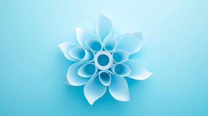 Creative arrangement of light blue paper rolls forming floral-like pattern on matching blue background