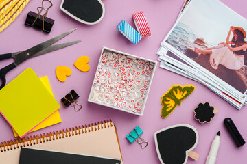 Crafting supplies for scrapbooking arranged on a purple surface